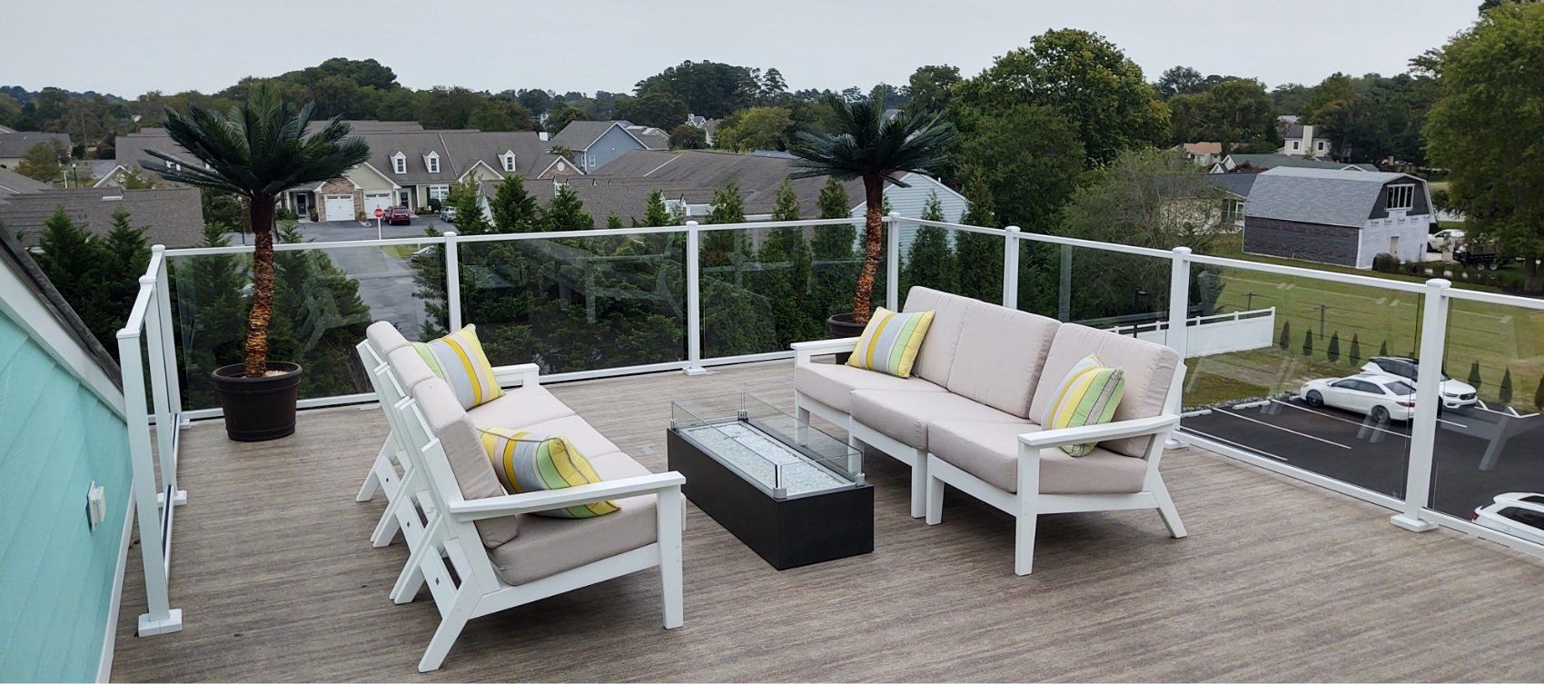 A rooftop deck with a couch , chairs , and a table.