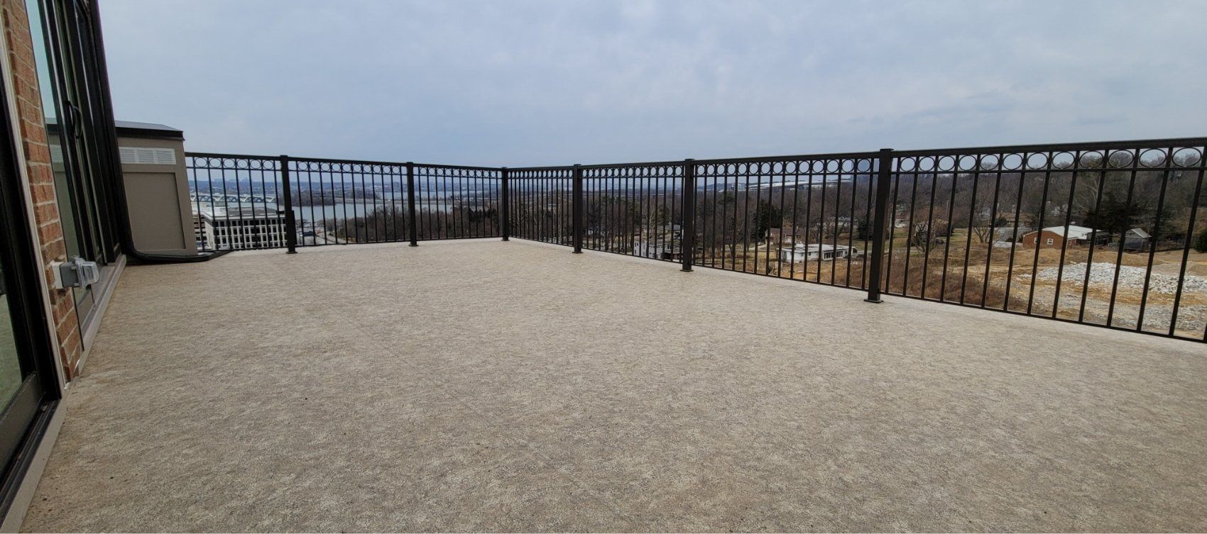 A balcony with a railing and a view of a city.