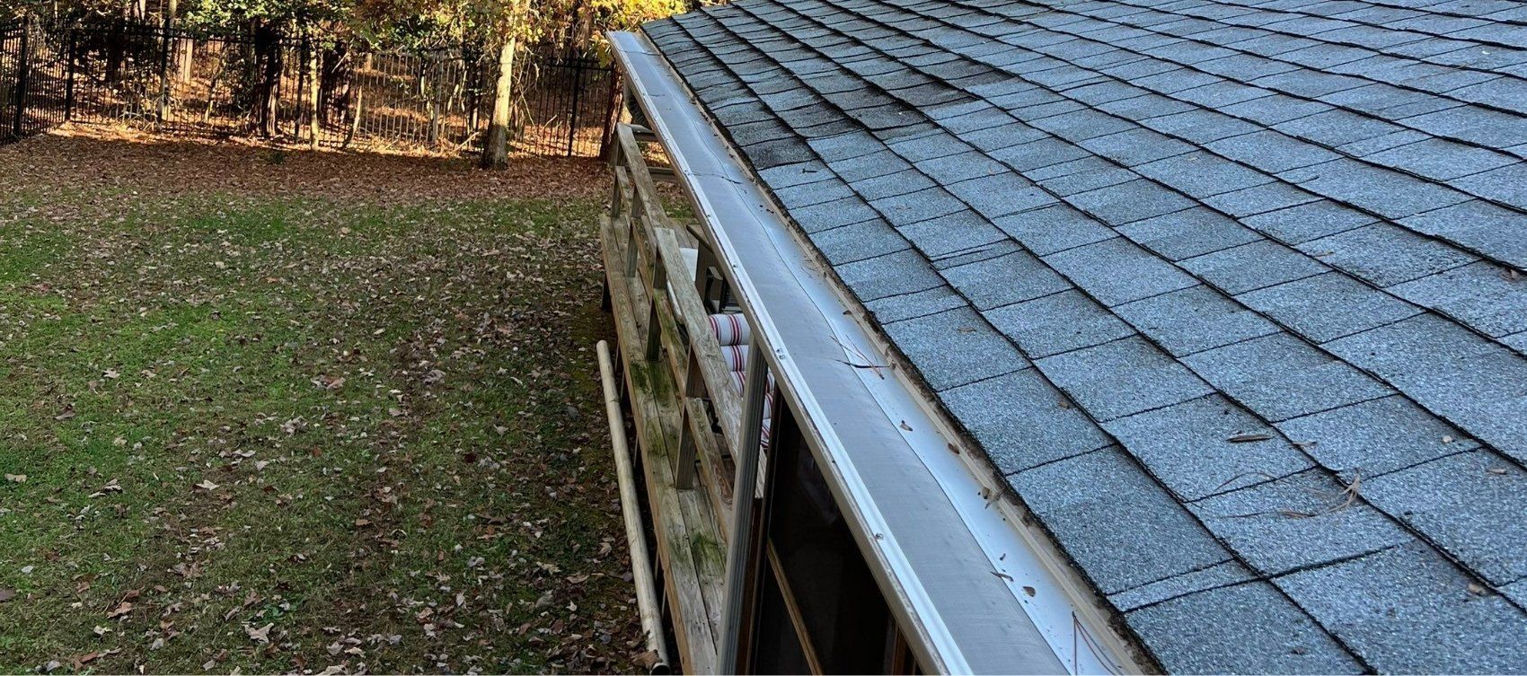 A close up of a gutter on the side of a house.