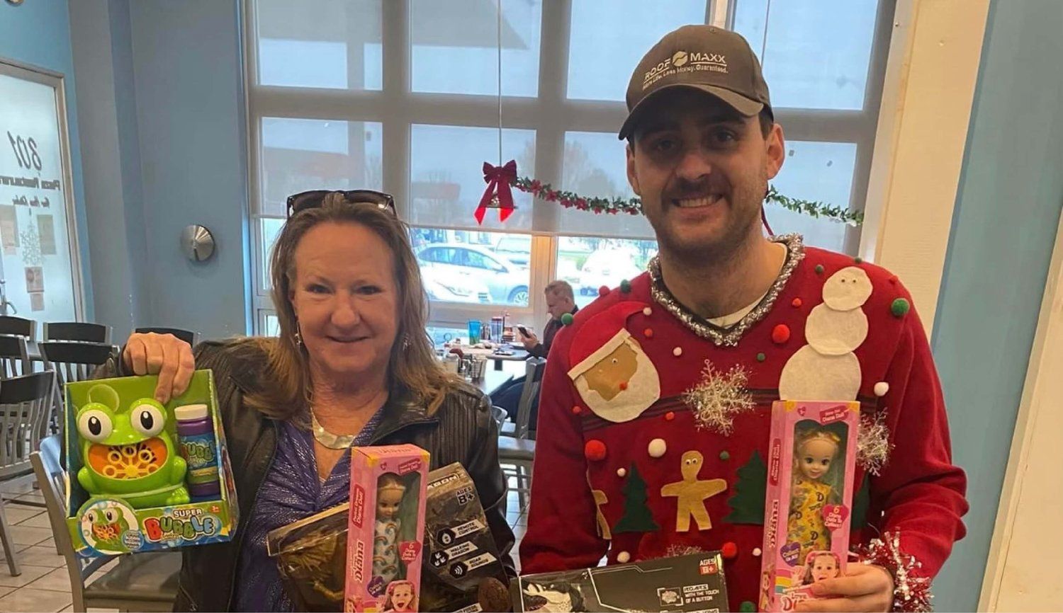 A man and a woman are standing next to each other holding toys.