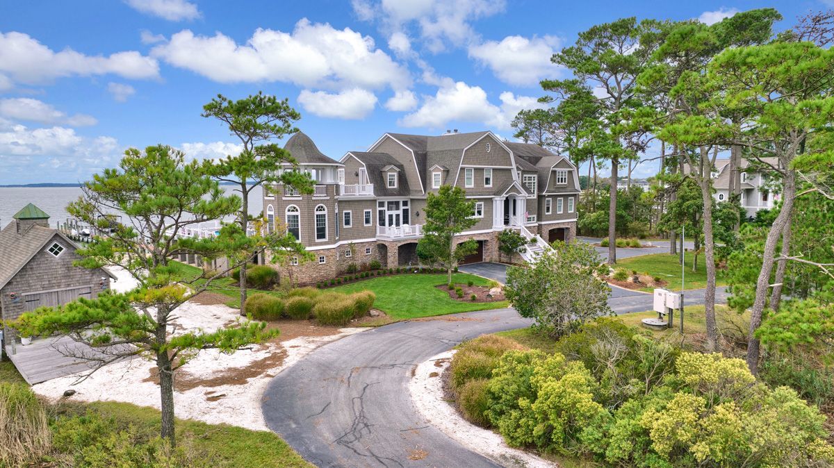 An aerial view of a large house surrounded by trees and bushes.