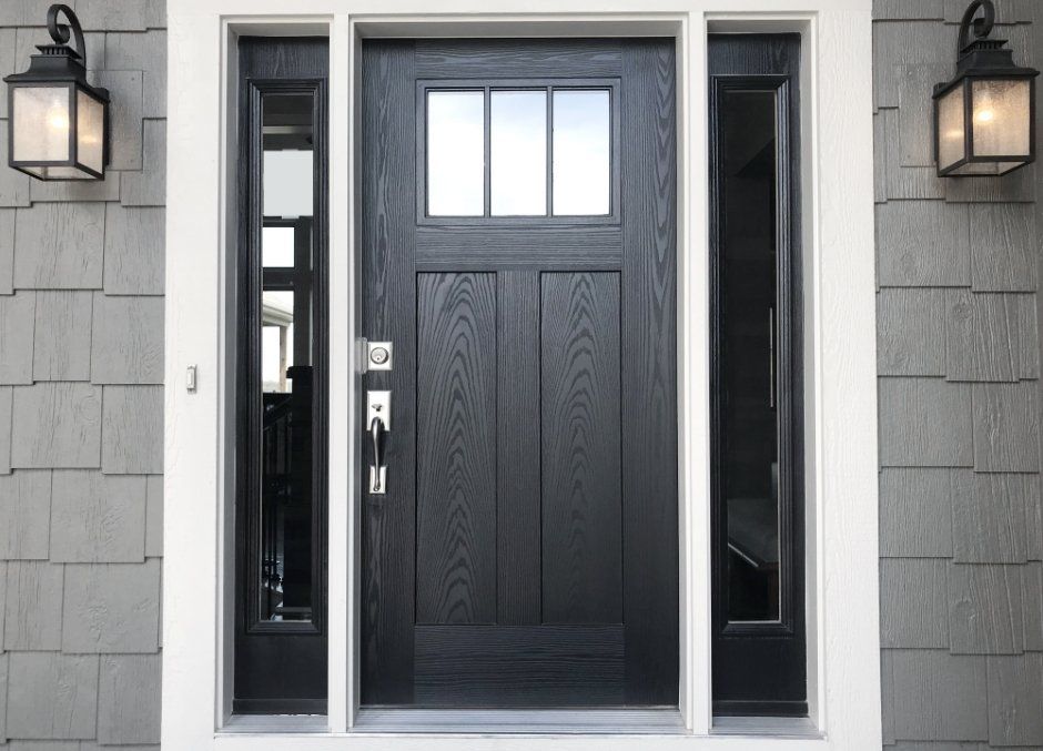 The front door of a house with a black door and two windows