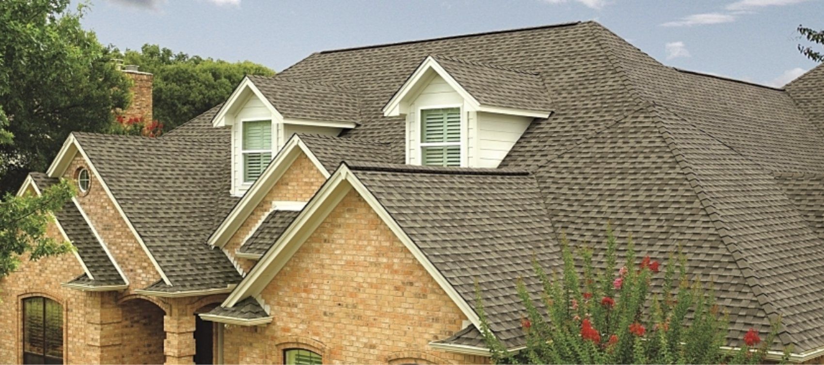 A large brick house with a gray roof and white trim