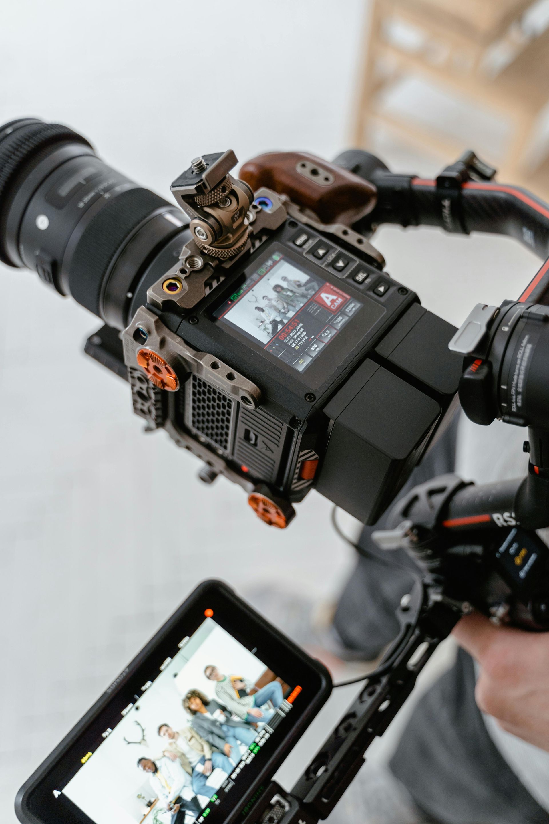 A person is holding a camera with a screen attached to it.