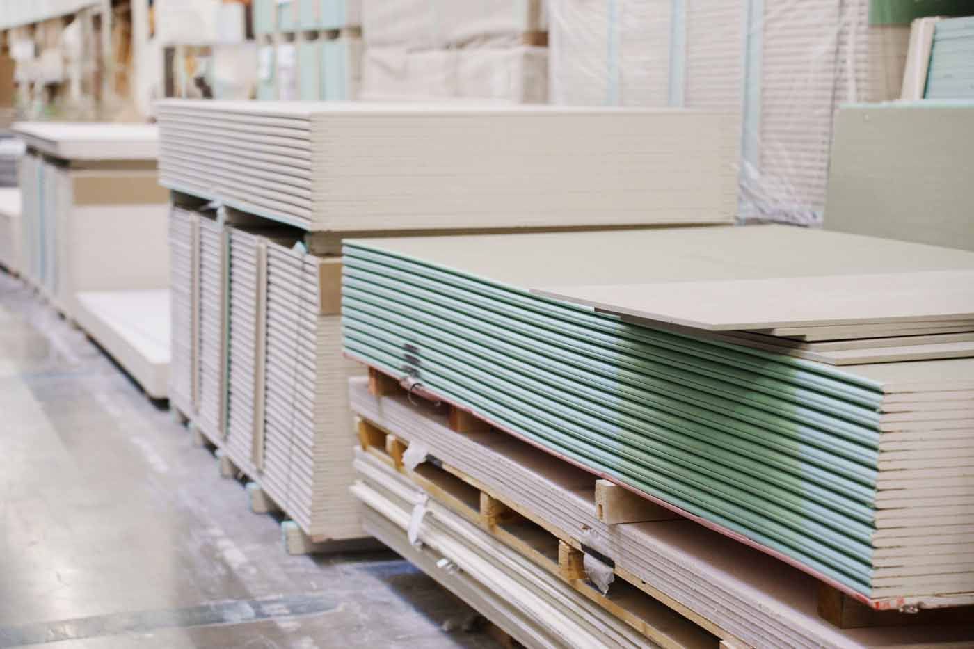 A warehouse filled with stacks of drywall sheets.