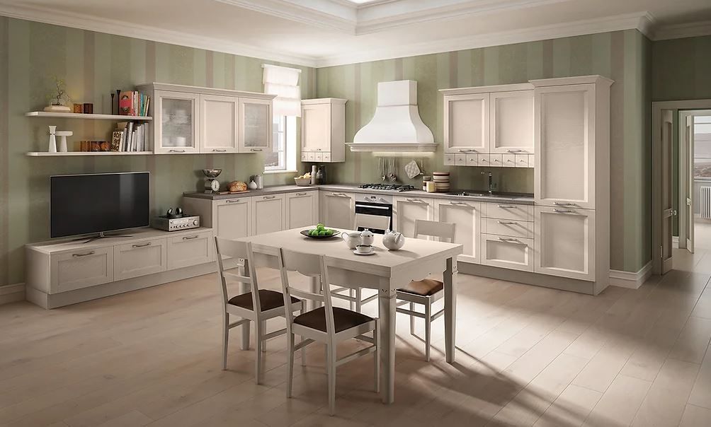 Elegante cucina con mobili color crema, tavolo da pranzo, fornelli e TV a parete. Pareti a strisce verde chiaro.