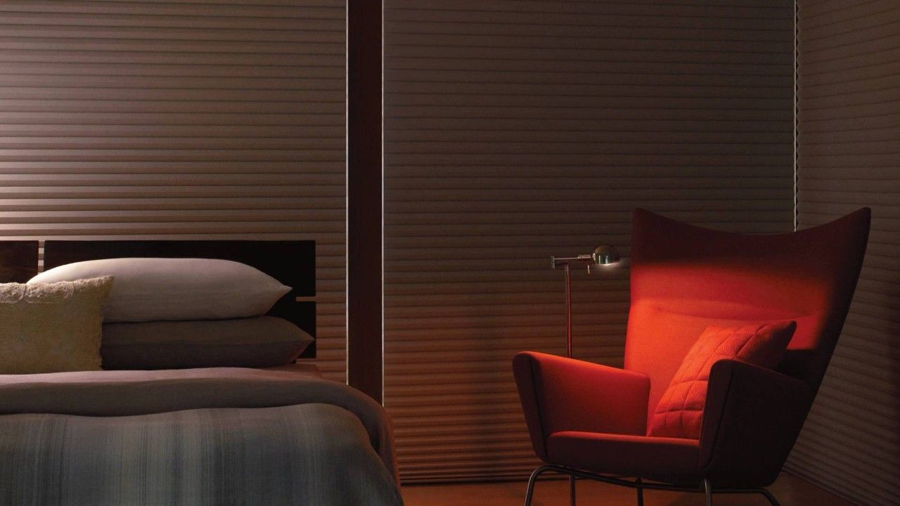 A bedroom with a bed and a red chair