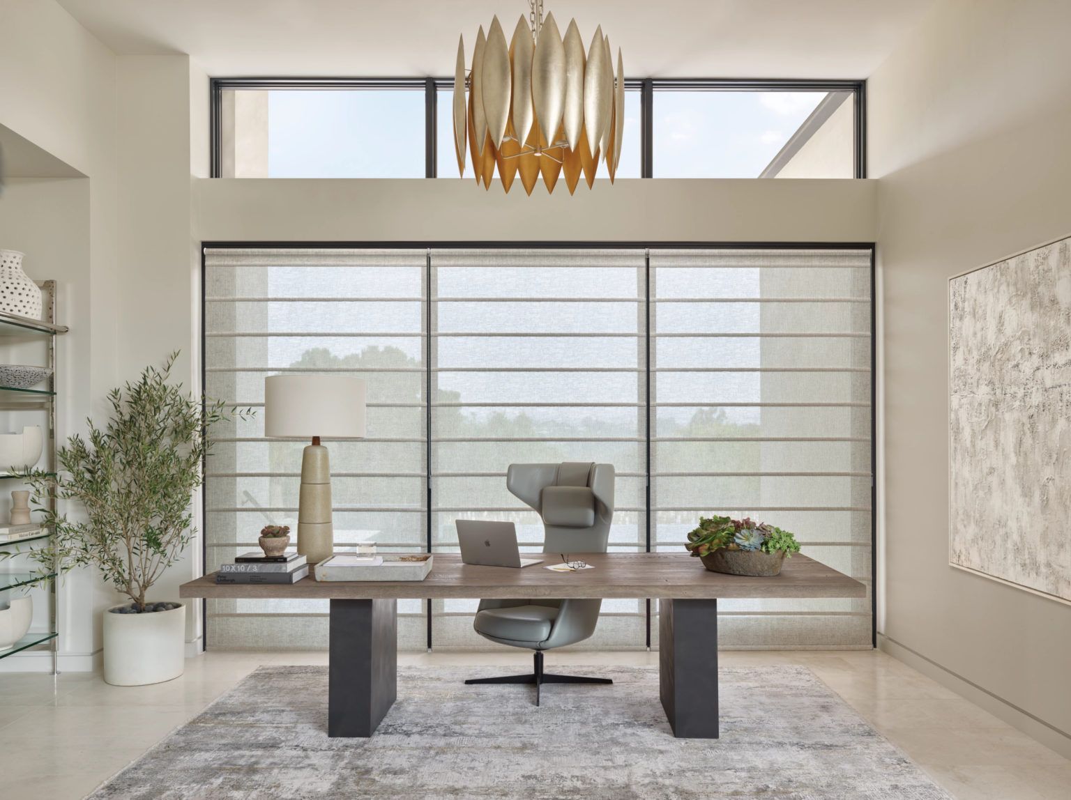 A home office with a desk and chair in front of a large window.