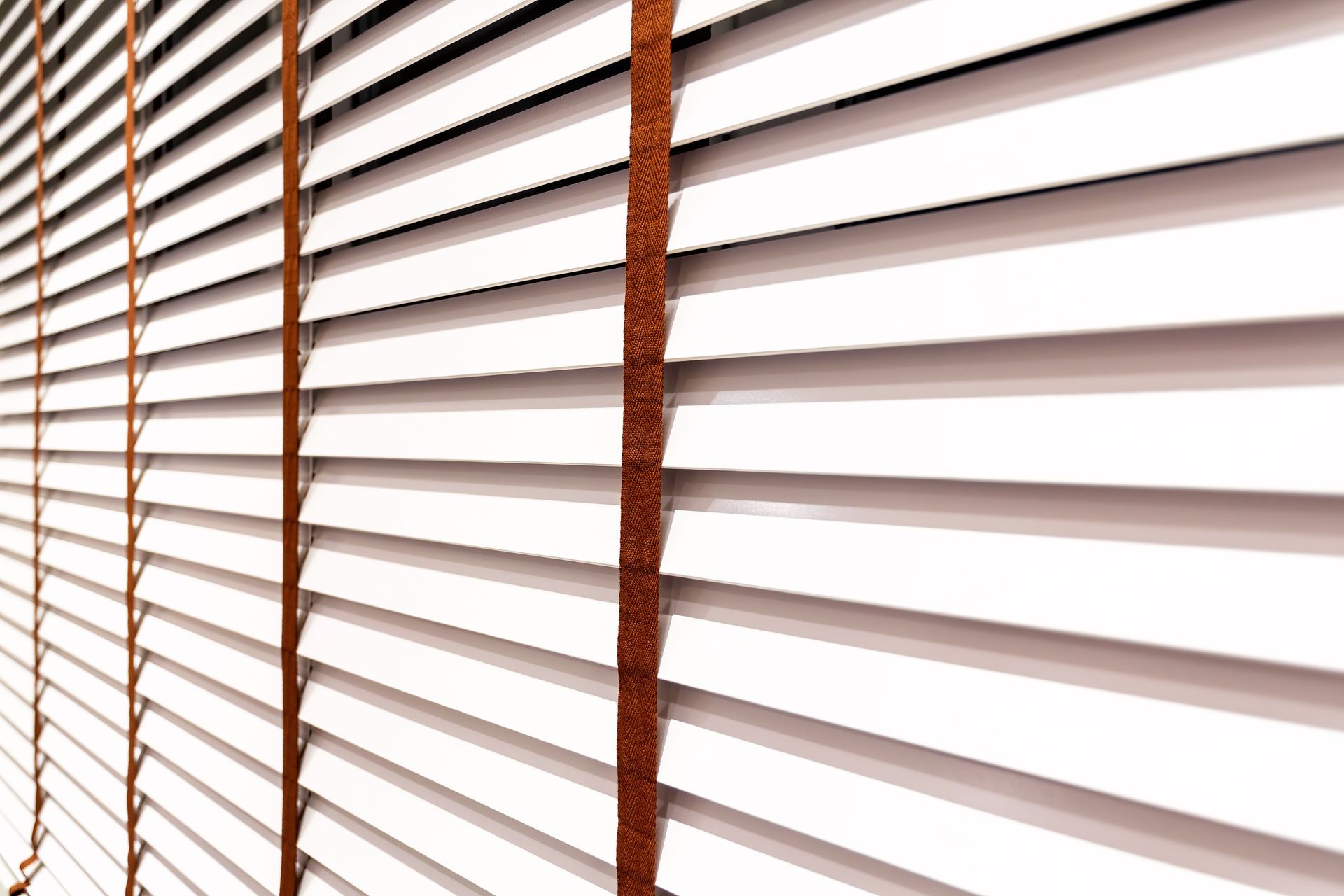 An elegant set of white wooden window blinds
