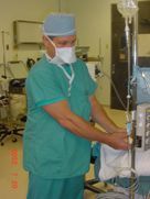A surgeon is preparing a patient for surgery in an operating room.