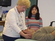 A woman is giving a man a massage in a room.