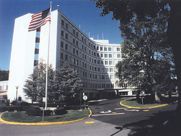 A large white building with an american flag on top of it.