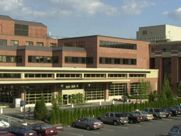 A large brick building with a lot of cars parked in front of it.