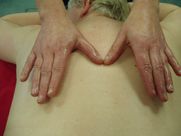 A woman is getting a massage with her hands on her back.