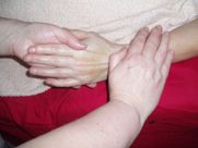 A person is giving a massage to another person 's arm.