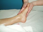 A person is getting a foot massage on a bed.