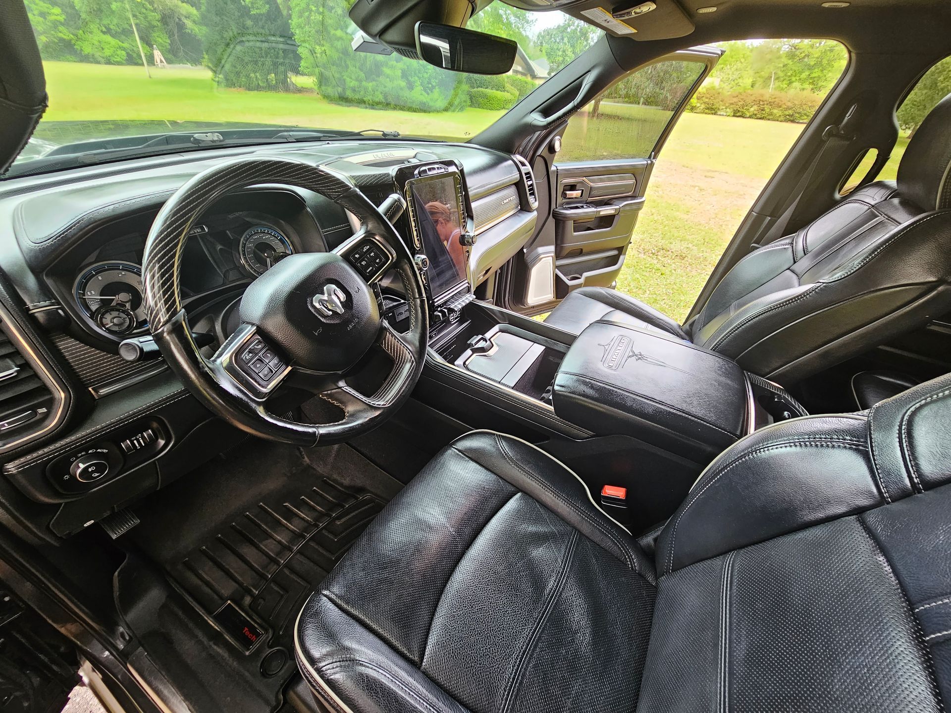 The interior of a ram truck with black leather seats and a steering wheel.