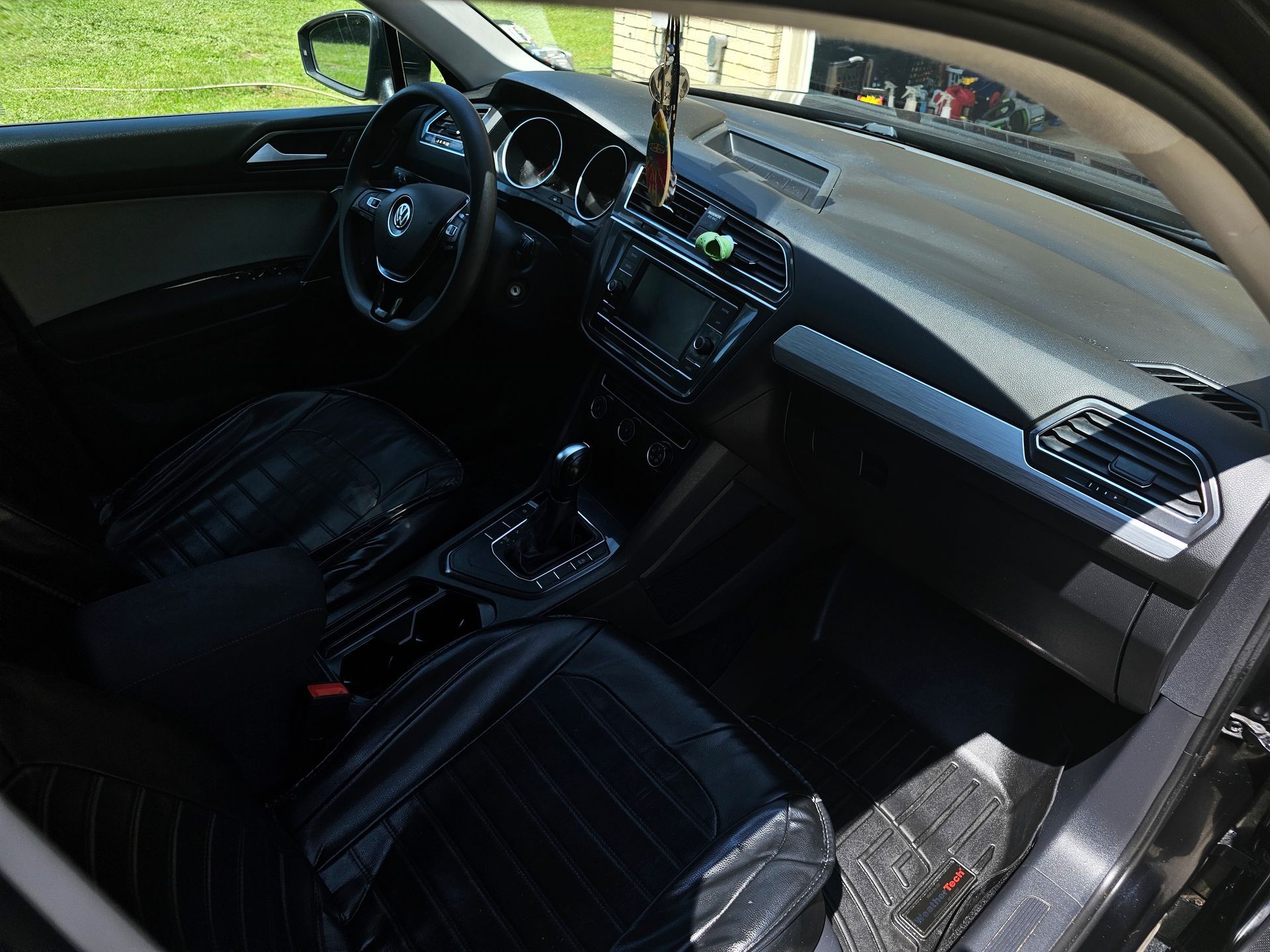 The inside of a car with a steering wheel and dashboard