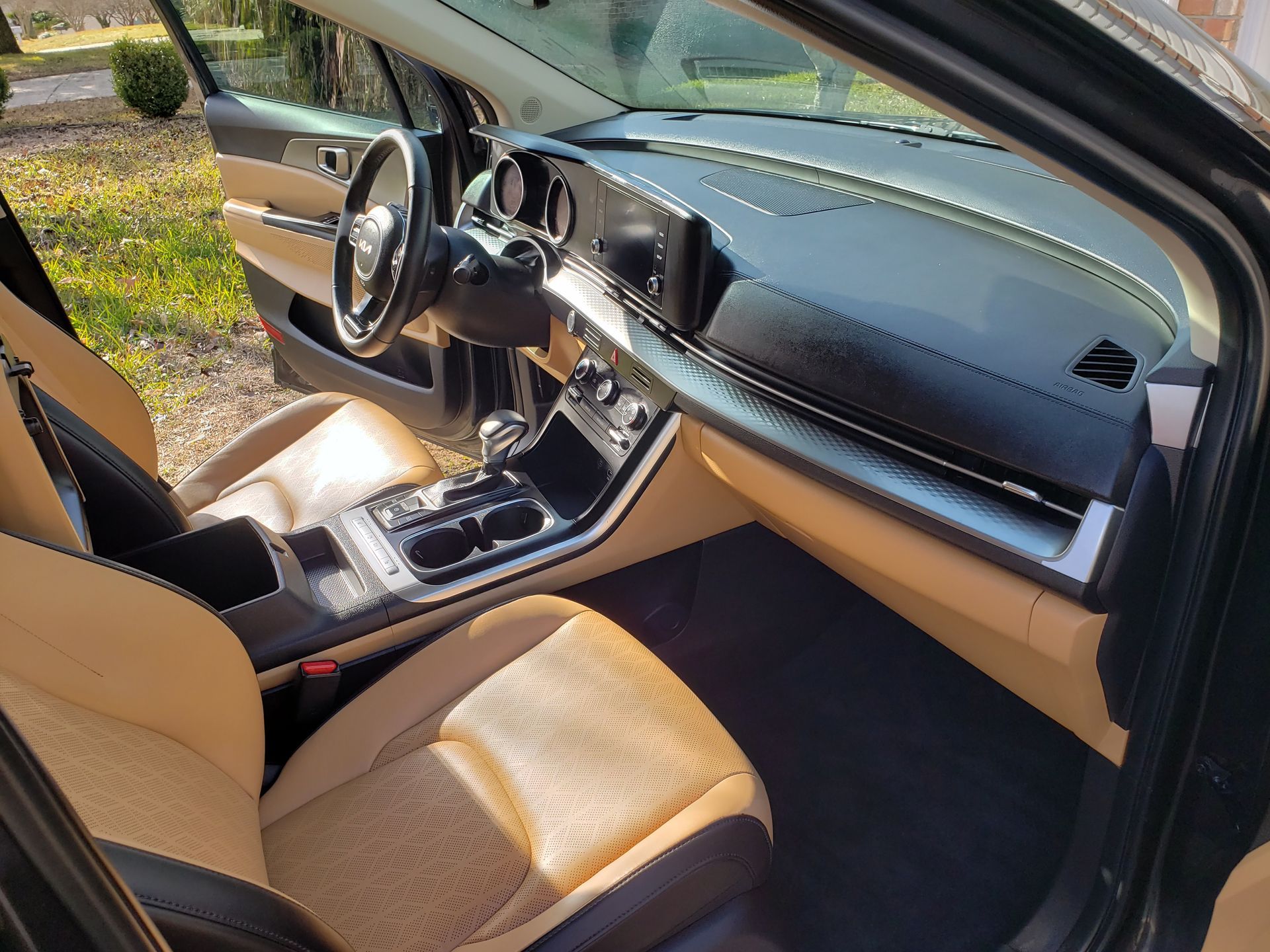 The interior of a black car with tan seats