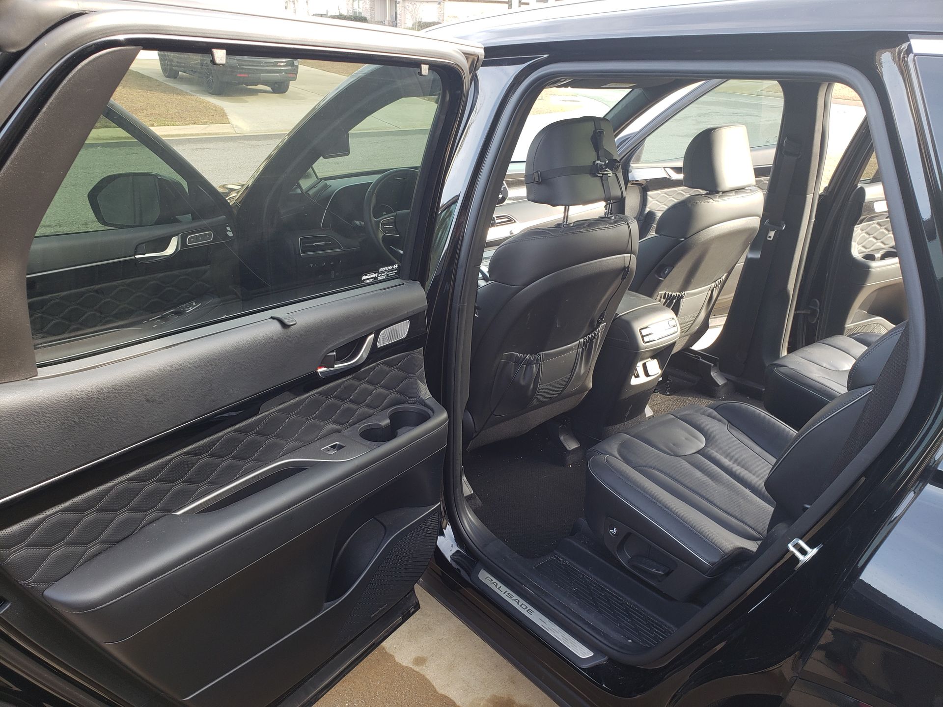 The inside of a black car with the doors open