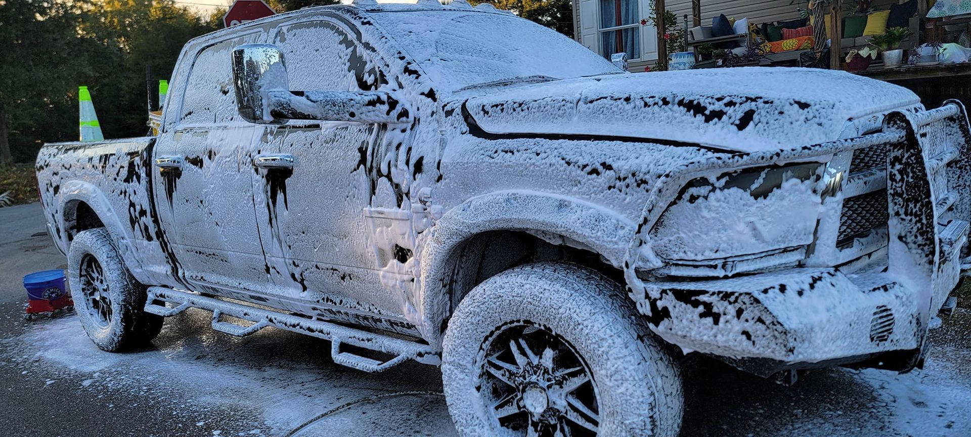 A truck covered in foam is parked on the side of the road.