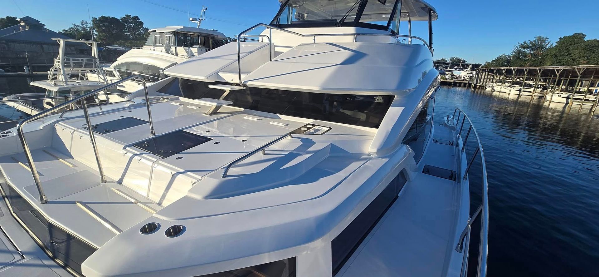 A large white boat is docked in a marina next to a body of water.
