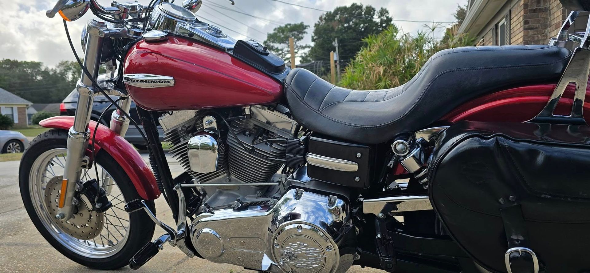 A red harley davidson motorcycle is parked on the side of the road.