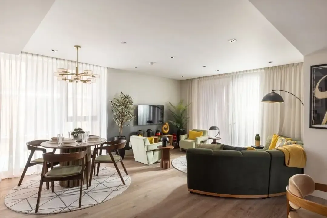 Modern kitchen with gray cabinets, round dining table set for four, and warm wood accents