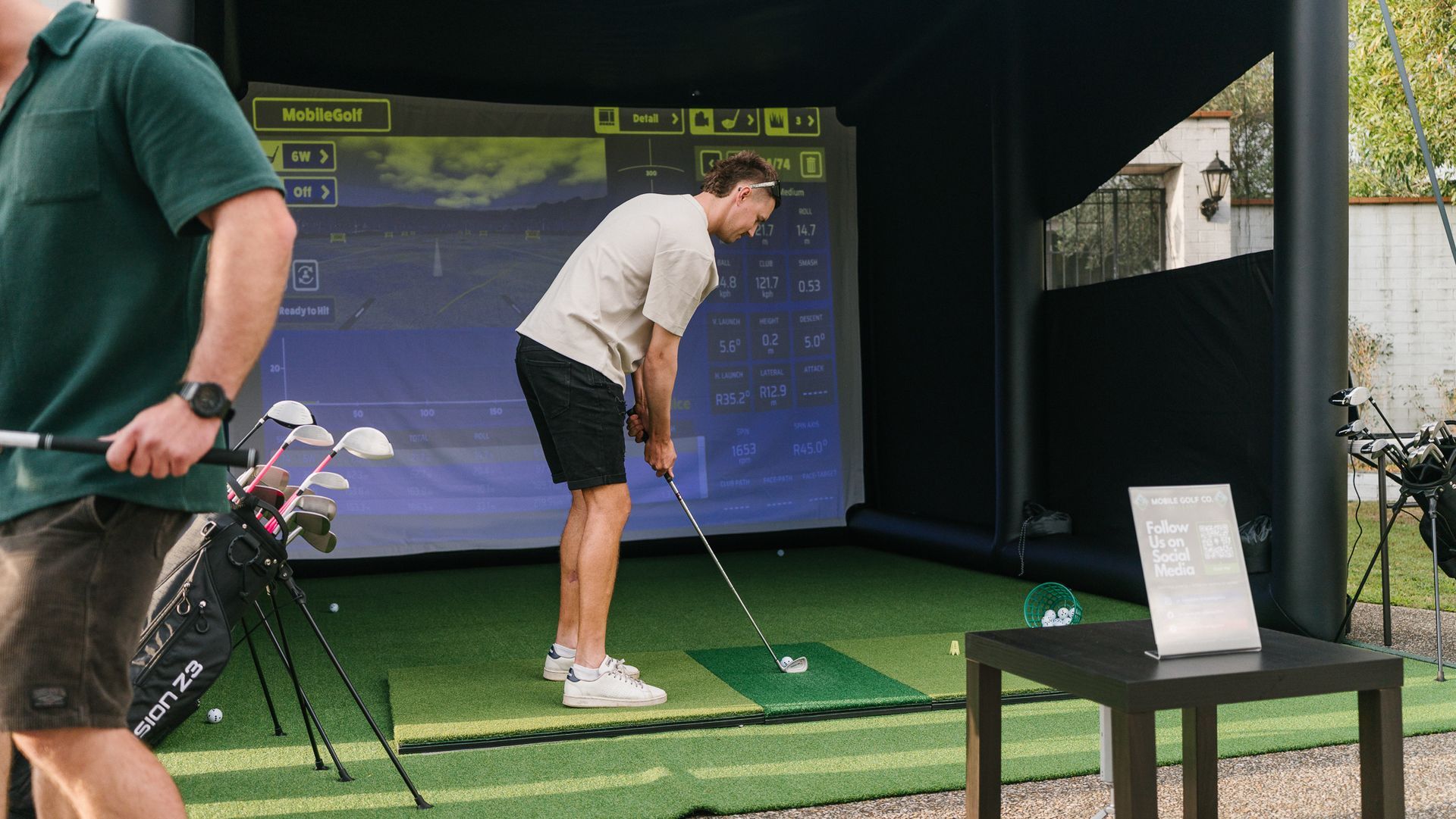 titleist golf ball resting on the green next to the hole with a flag in it.