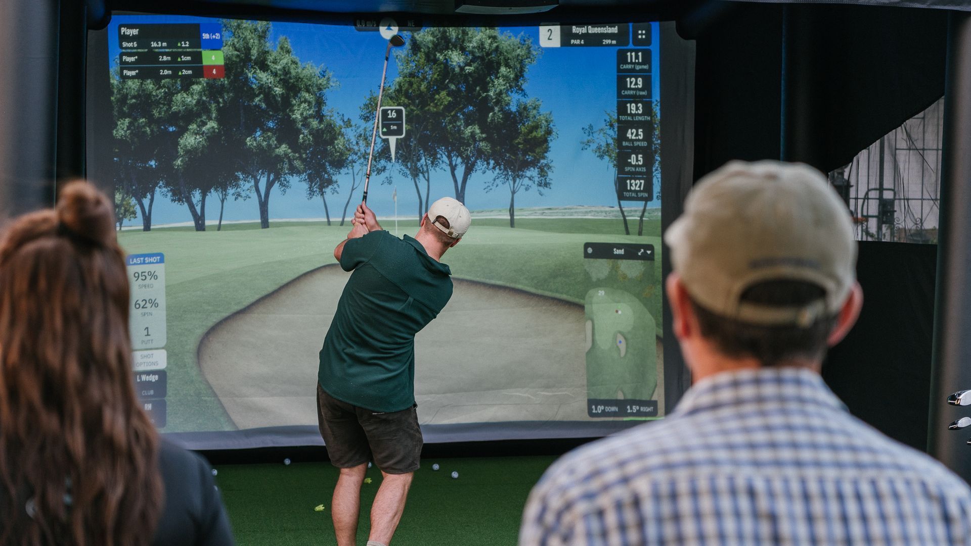 golf club resting behind golf ball on the grass, ready to take a shot