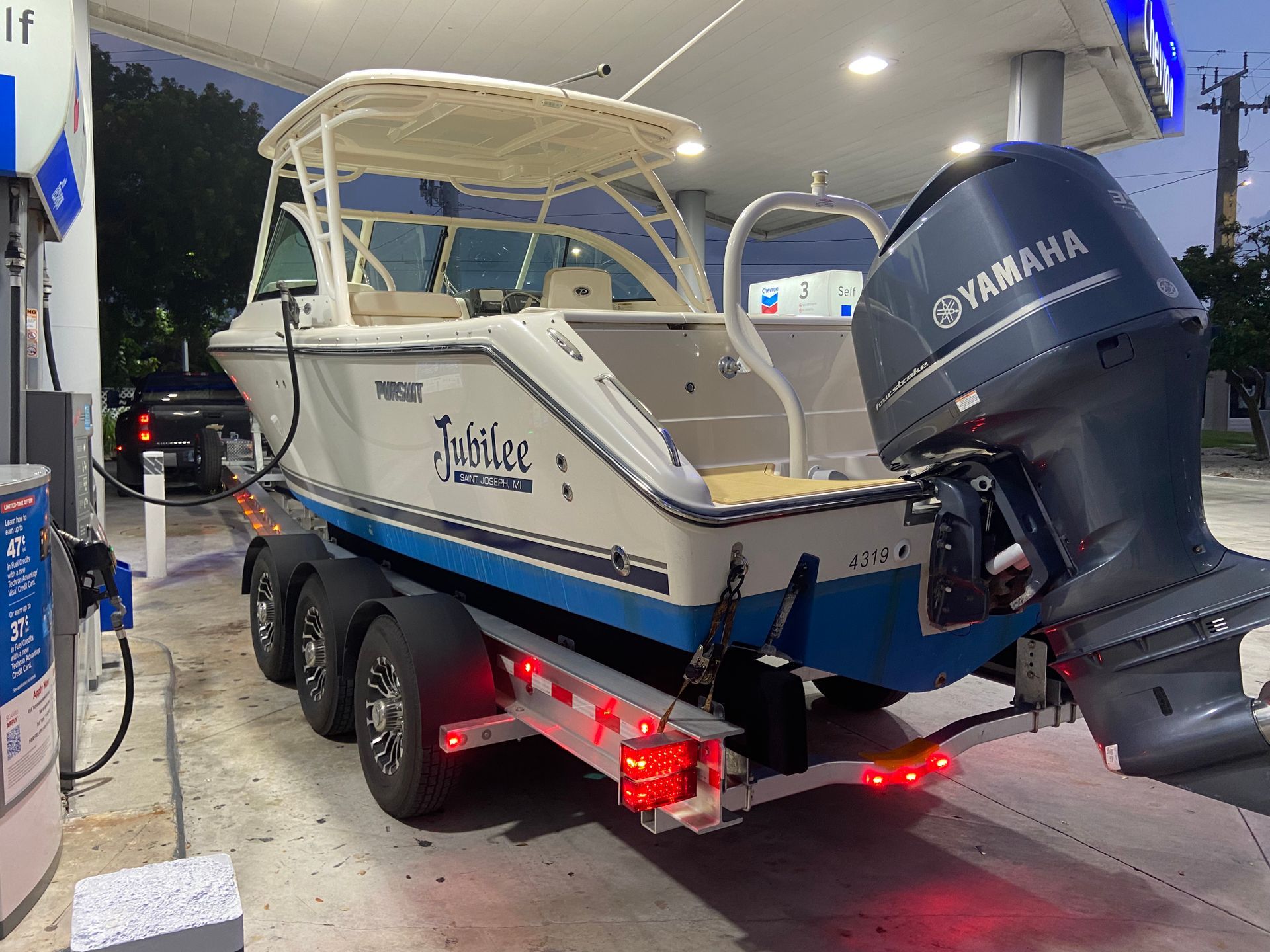 A boat with a yamaha engine is parked at a gas station.