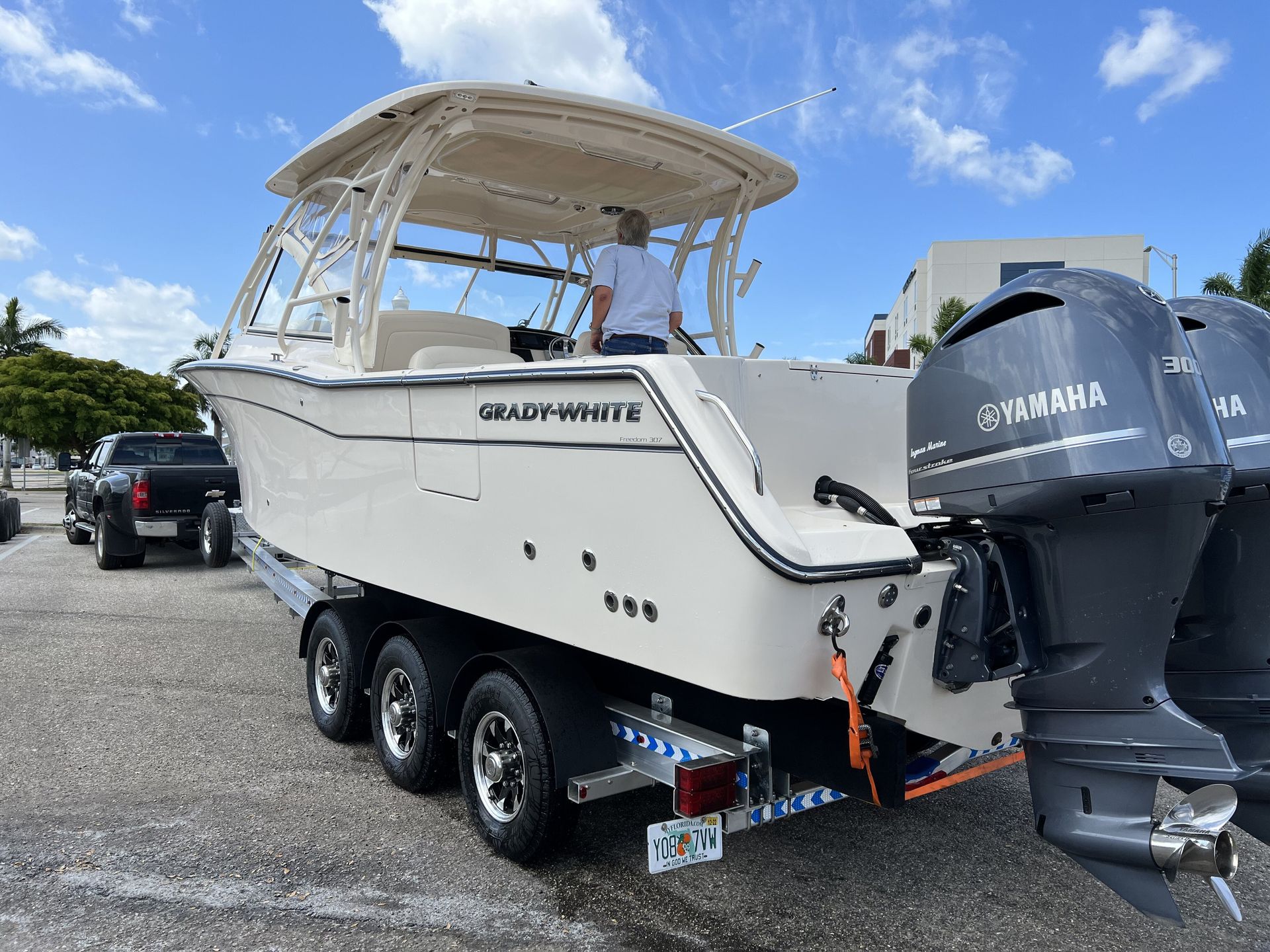 A boat with a yamaha engine is parked in a parking lot.