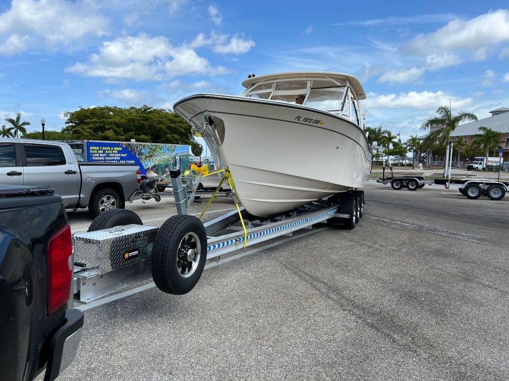 A boat is being towed on a trailer by a truck.
