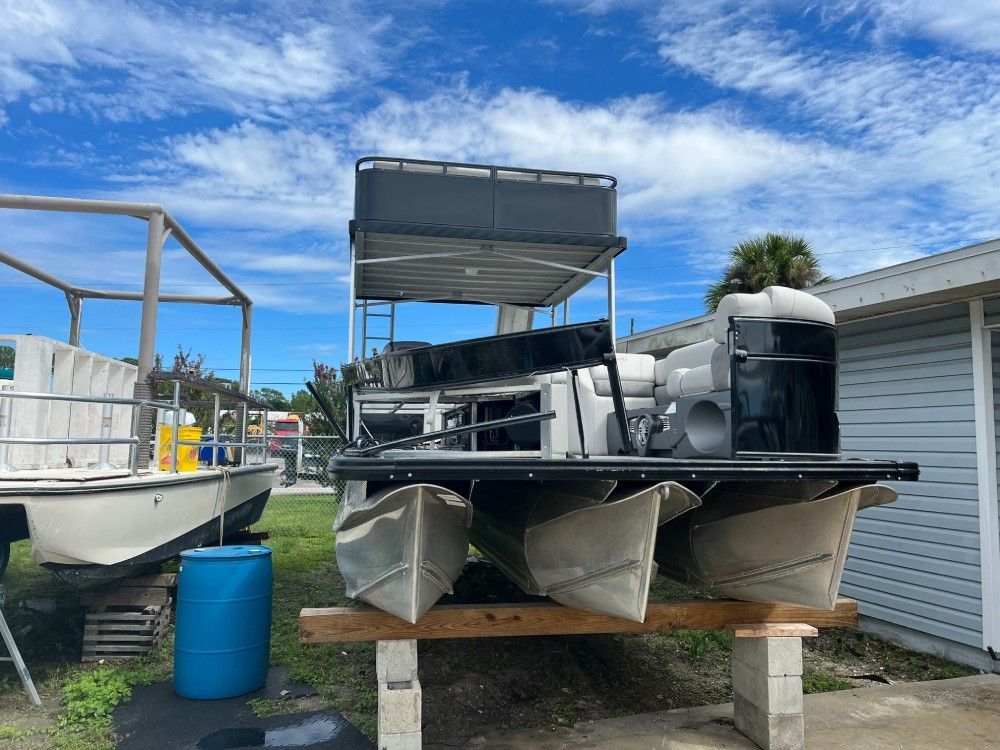 A row of pontoon boats are parked in front of a house.