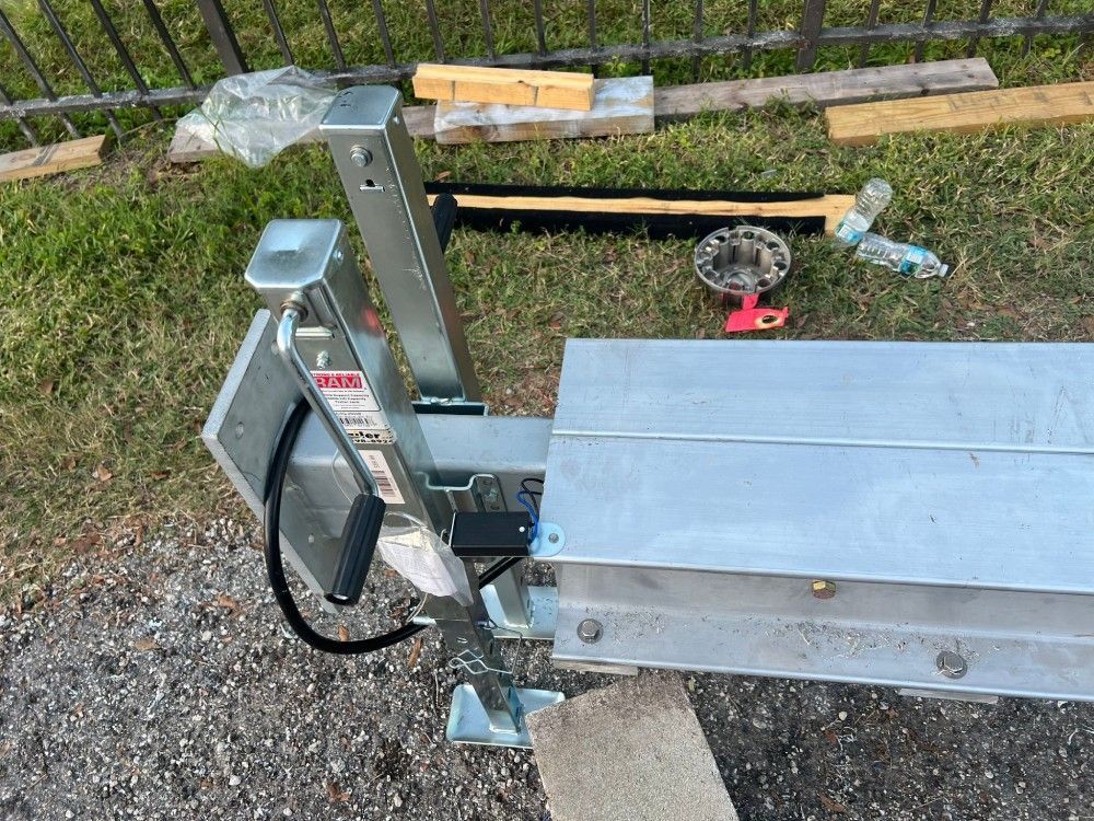 A piece of metal is sitting on the ground next to a fence.
