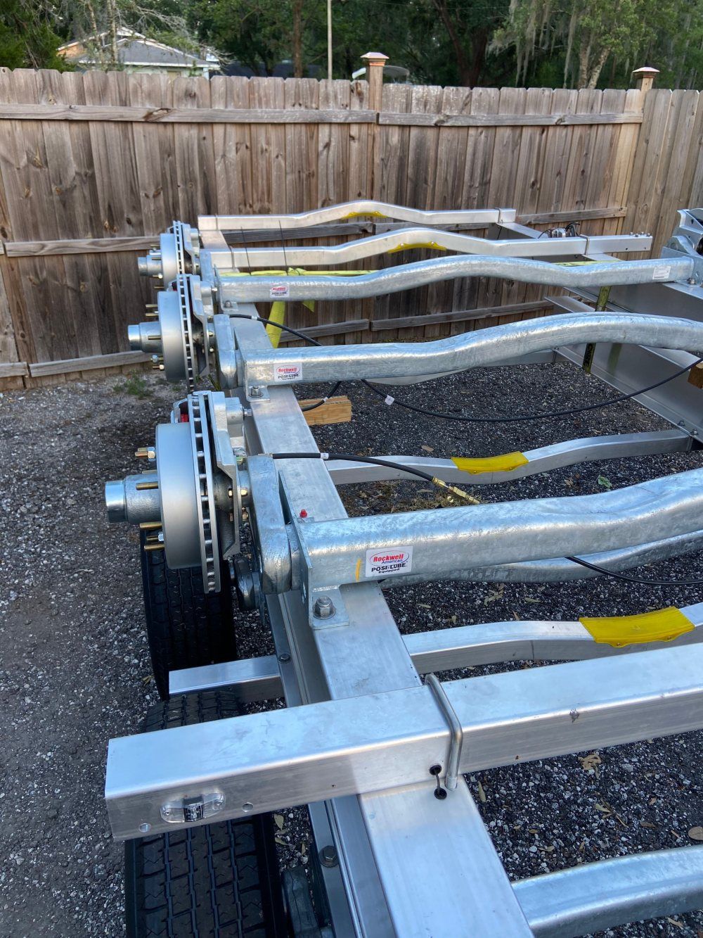 A trailer is parked in front of a wooden fence.