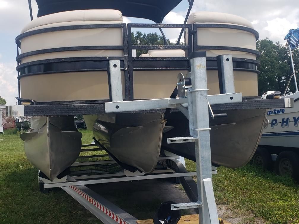 A pontoon boat is sitting on top of a trailer.