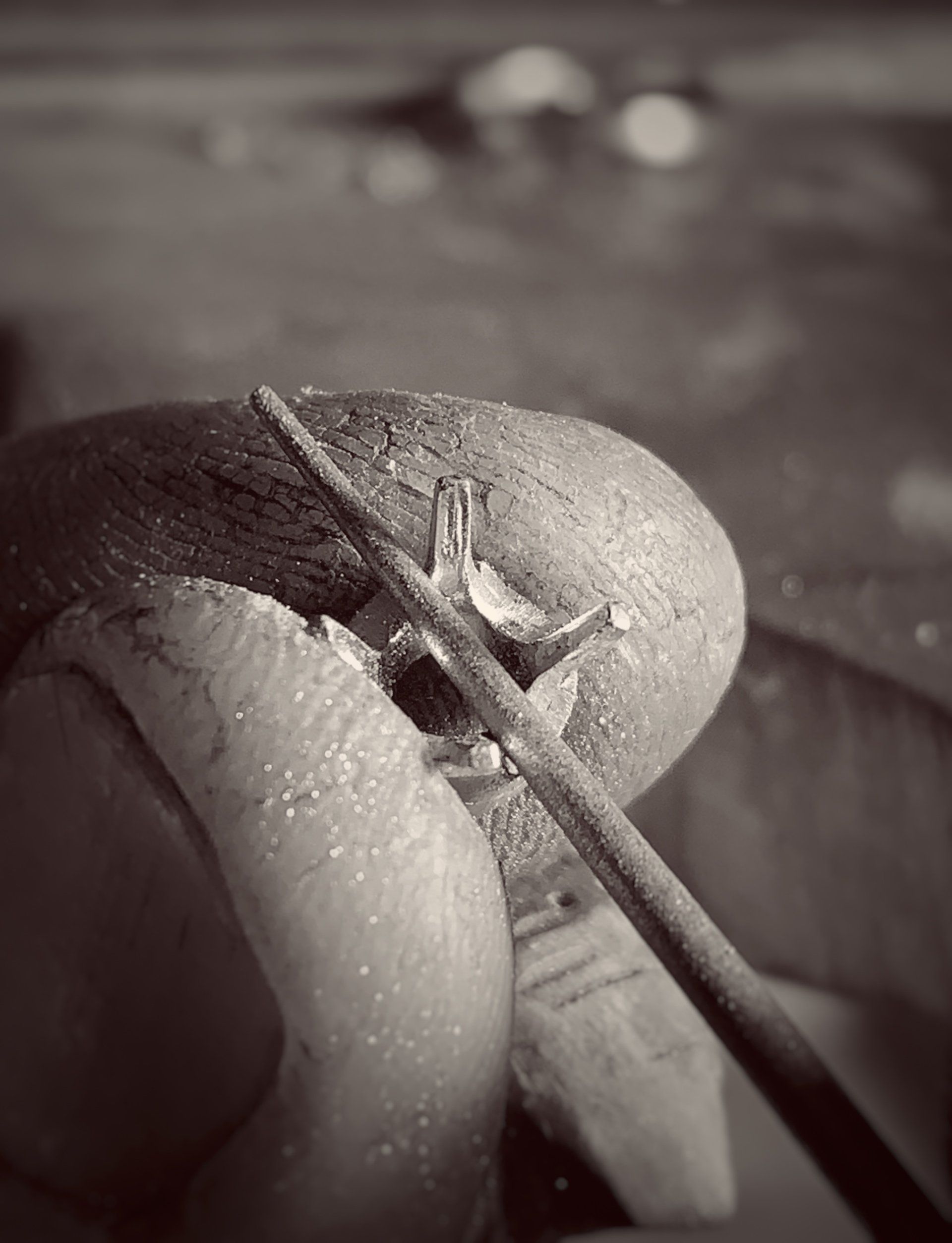 A black and white photo of a person working on a ring.