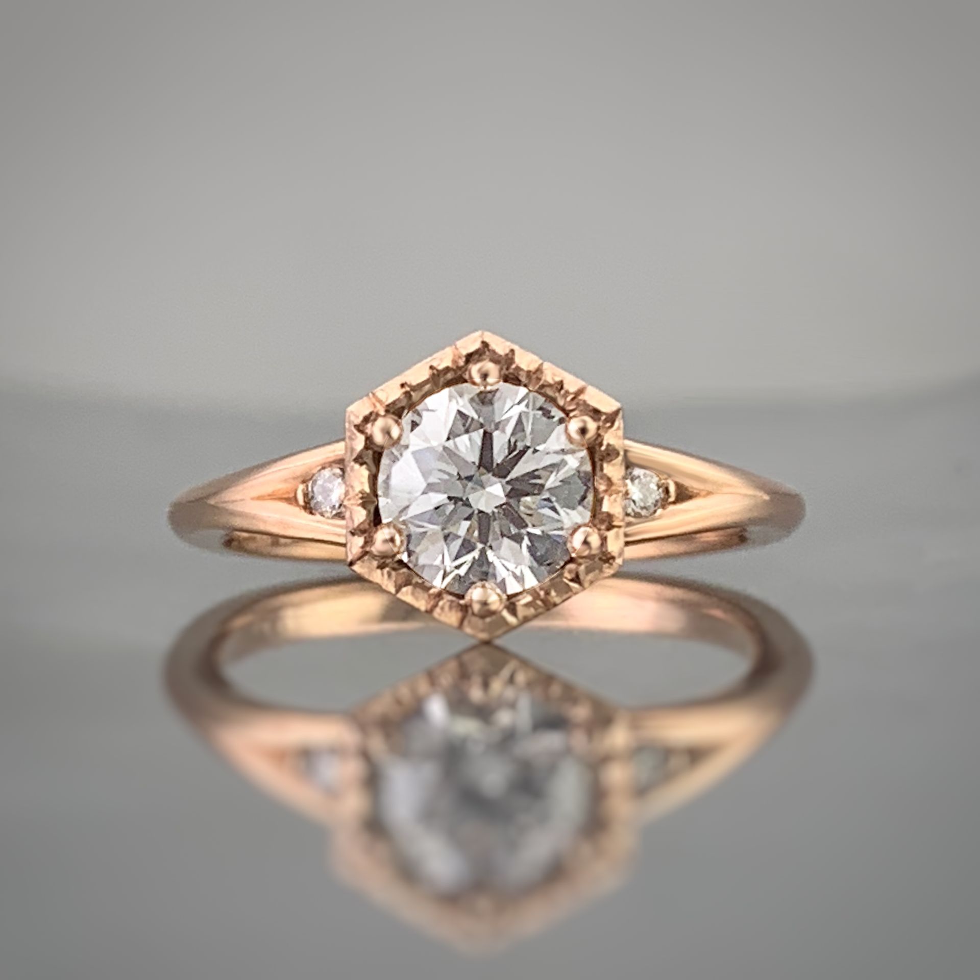 A ring with a diamond in the center is sitting on a table.