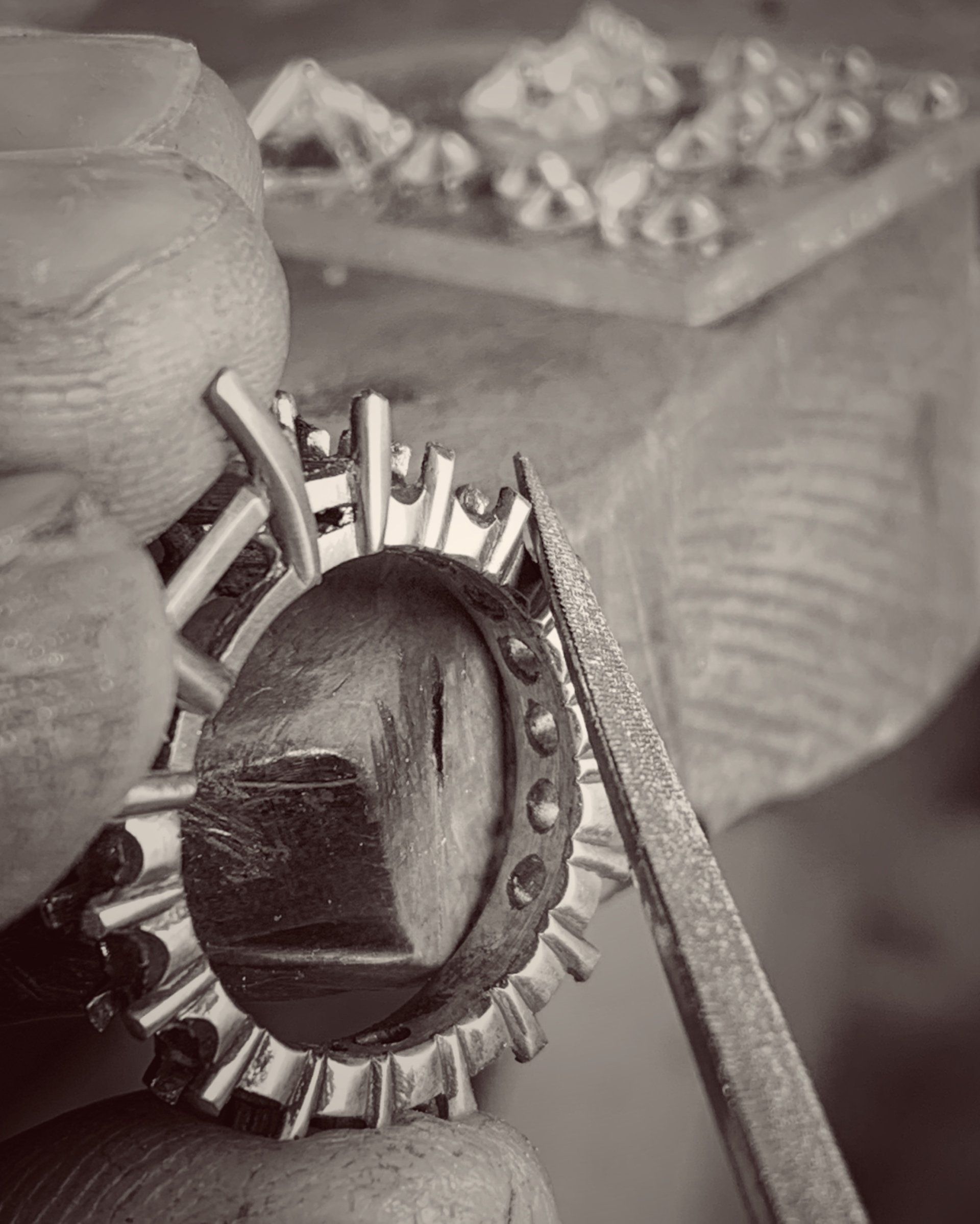 A black and white photo of a person working on a ring.