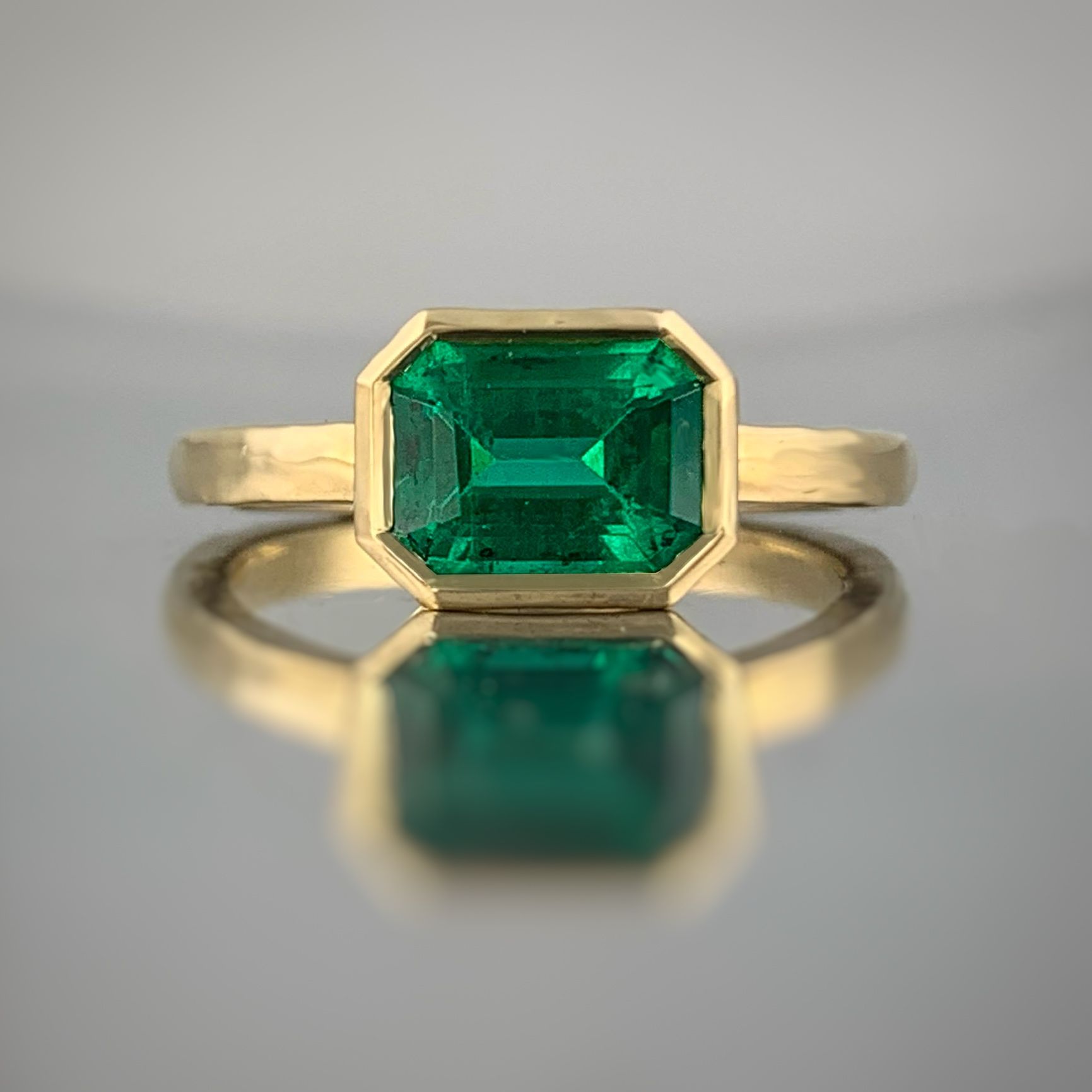 A yellow gold ring with an emerald in the center