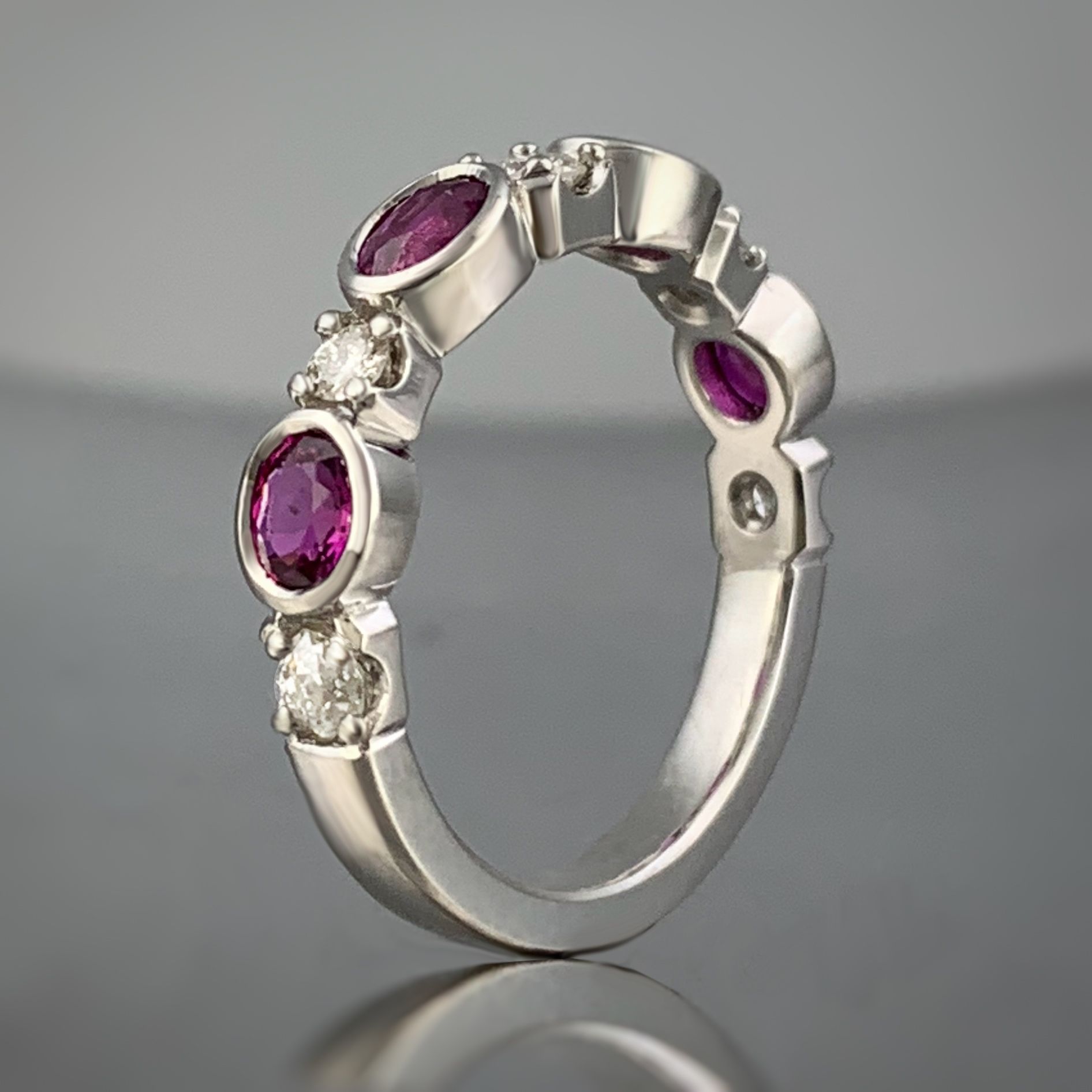 A white gold ring with purple stones and diamonds