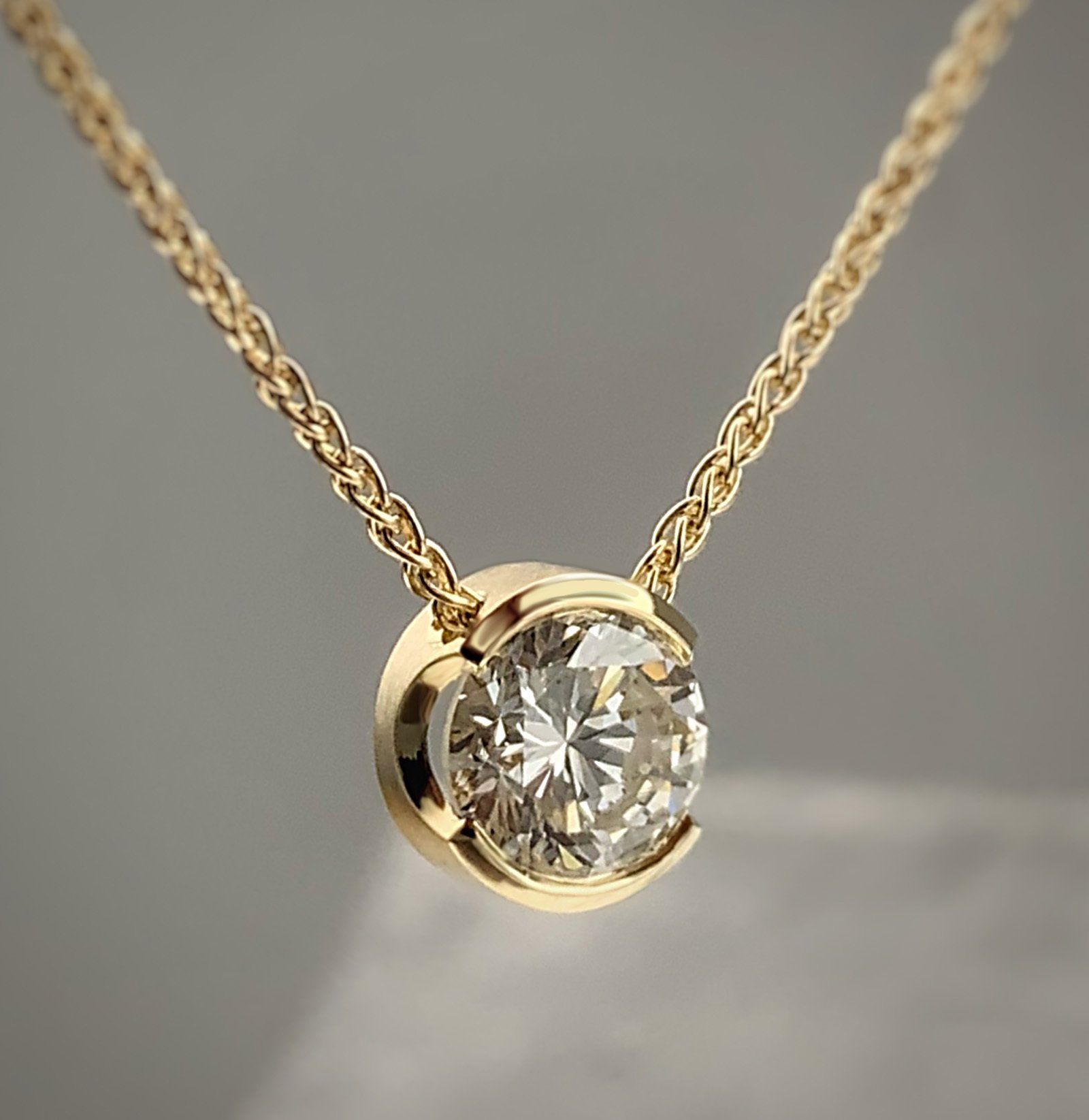 A yellow gold necklace with a diamond pendant