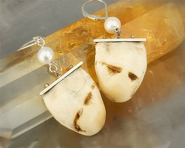 A pair of earrings sitting on top of a crystal