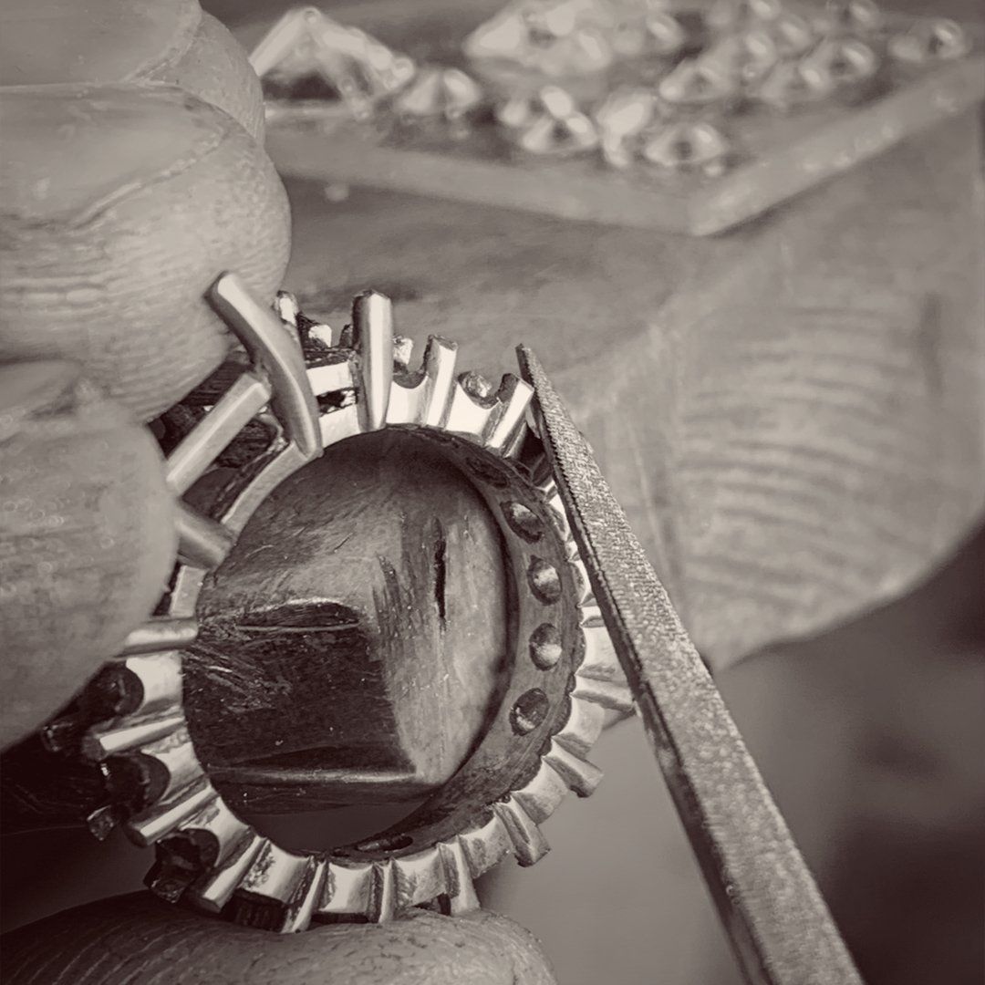 A black and white photo of a person working on a ring.