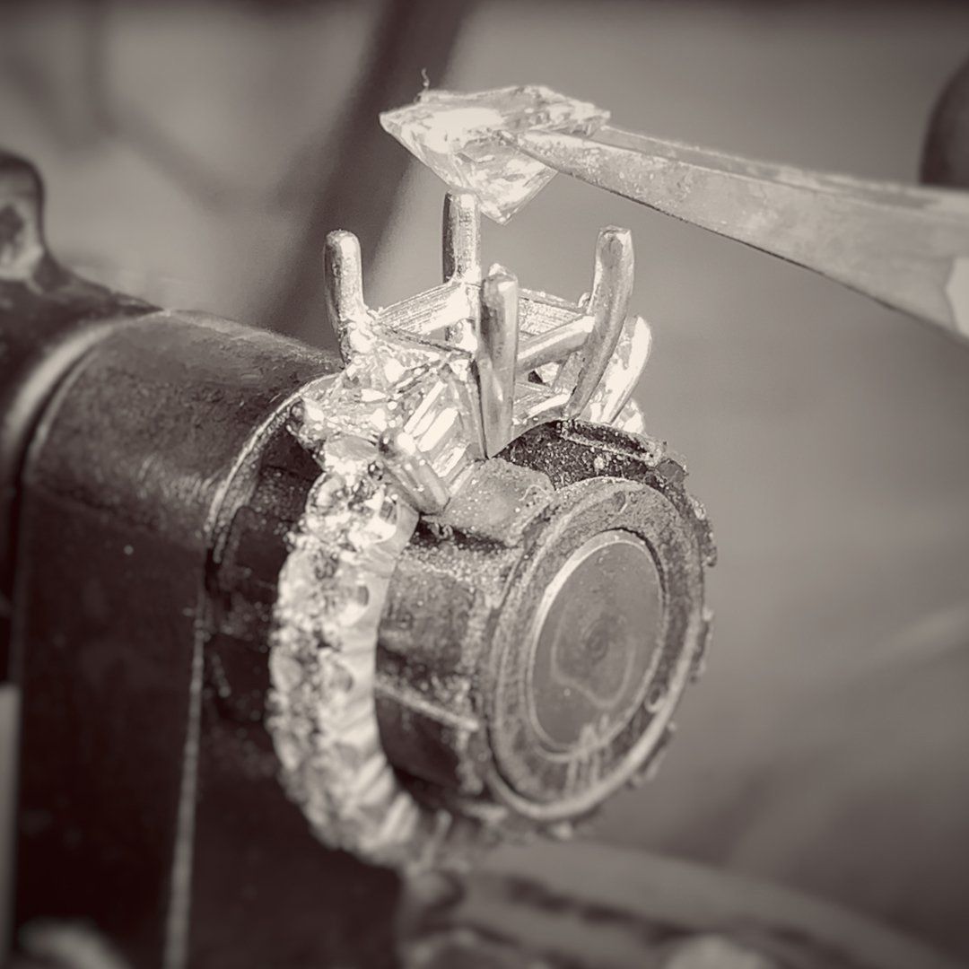 A black and white photo of a person working on a ring.