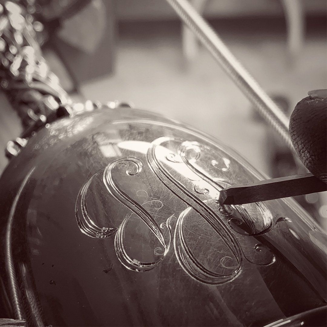 A black and white photo of a violin with the letter s on it