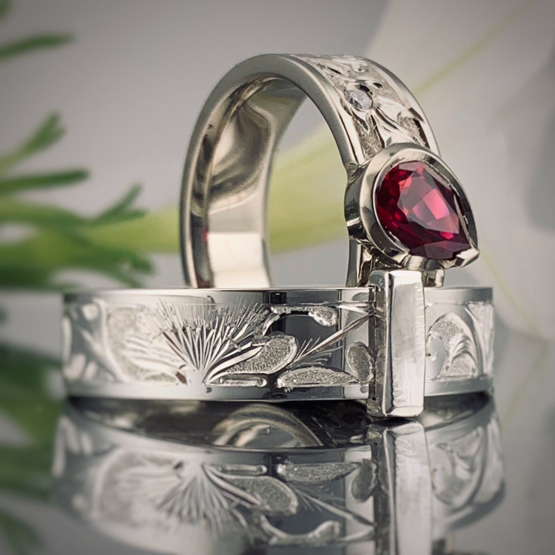 A silver ring with a red stone on it