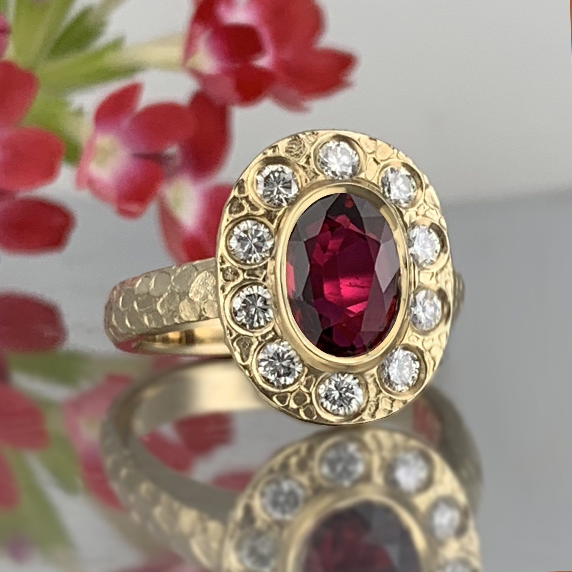 A gold ring with a red stone and diamonds