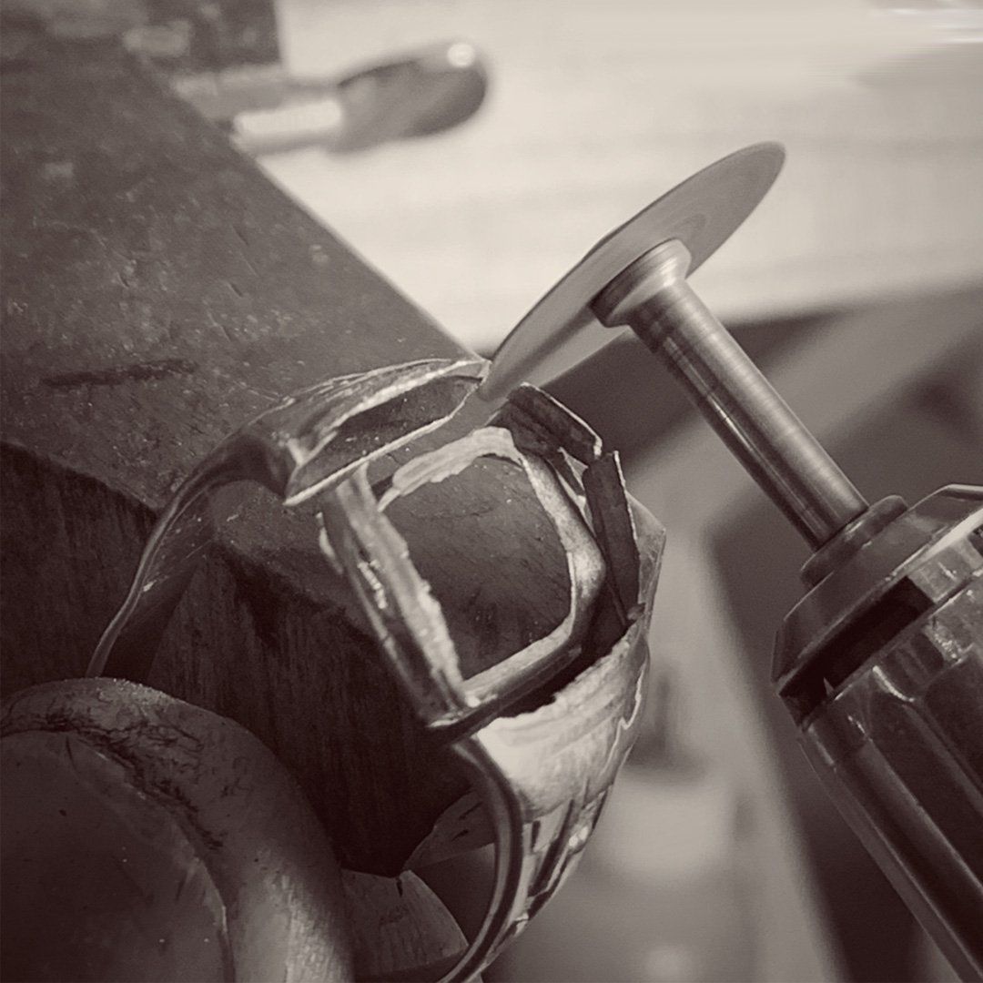A black and white photo of a ring being worked on